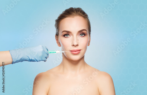 woman face and hand with syringe making injection