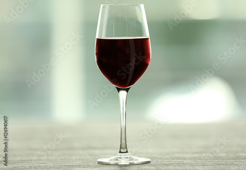 Glass with red wine on table