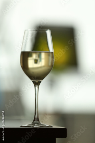 Glass with white wine on table