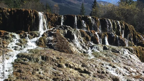 Waterfall stream at Huanglong Mountain with beautiful nature lime stone  in Sichuan , China on sunny day