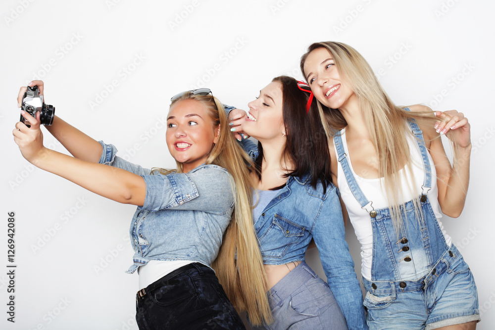 Happy girls friends taking some pictures with camera Happy girls friends taking some pictures with camera