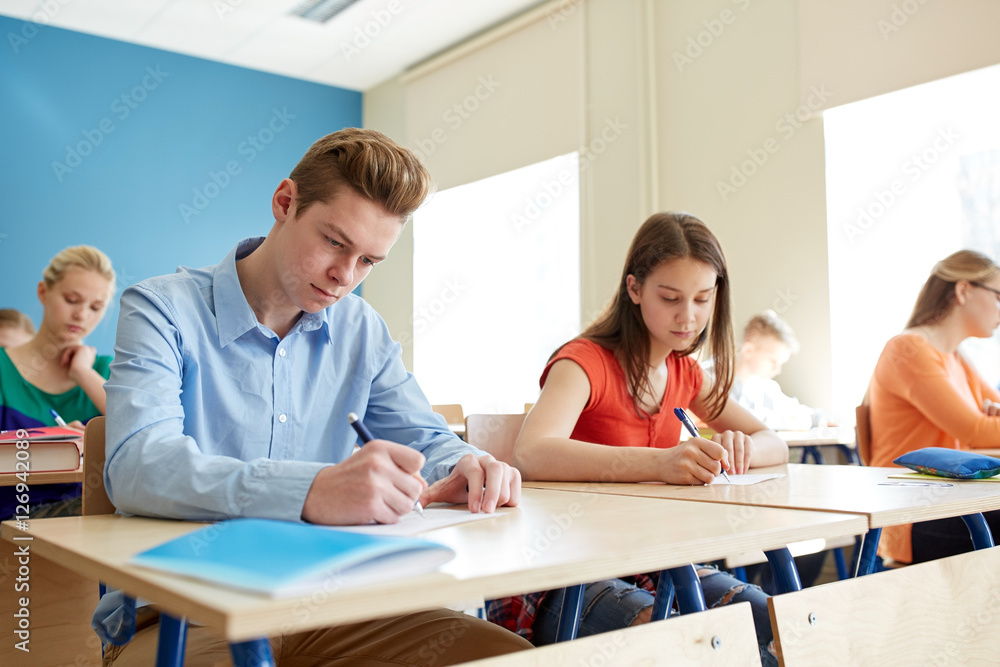 Obraz premium group of students with books writing school test