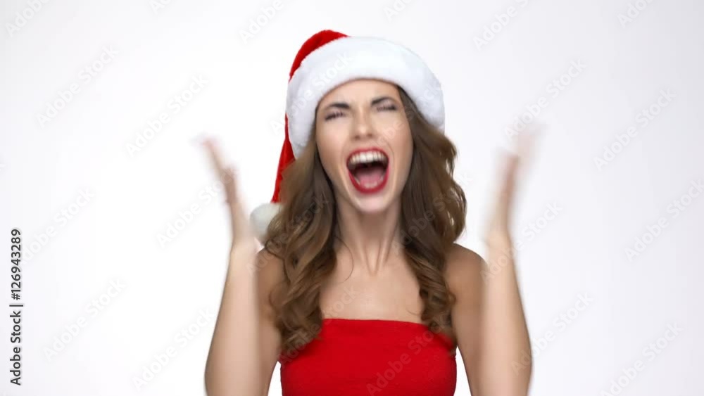 Angry young woman in santa claus costume shouting holding hands on head Angry young woman in santa claus costume shouting holding hands on head