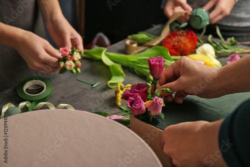 Female hands making beautiful flower composition in floral shop