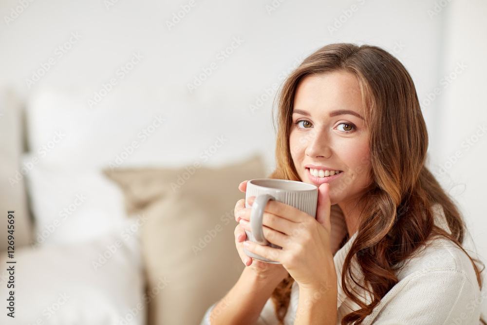 happy woman with cup of tea or coffee at home