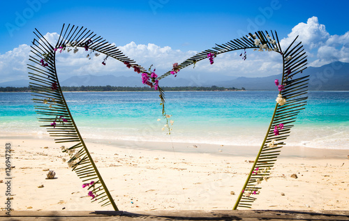 tropical beach with a haert of flowers at gili meno, indonesia photo