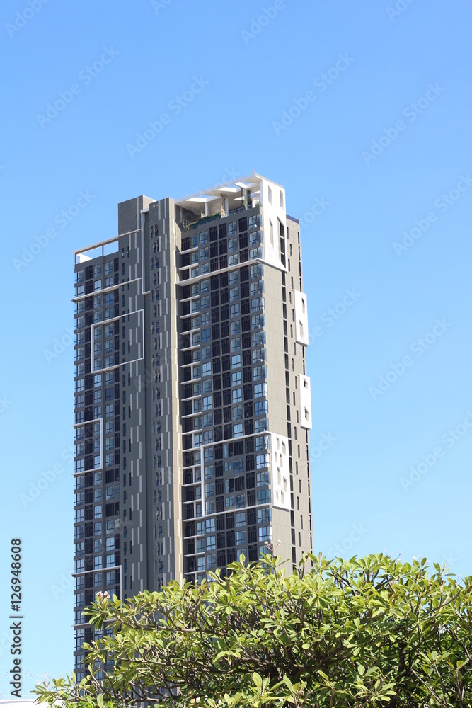 A modern high rise apartment tower against a blue sky A modern high rise apartment tower against a blue sky