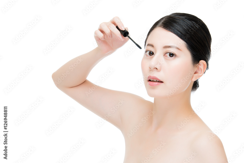 young beautiful asian woman applying mascara on eyelashes