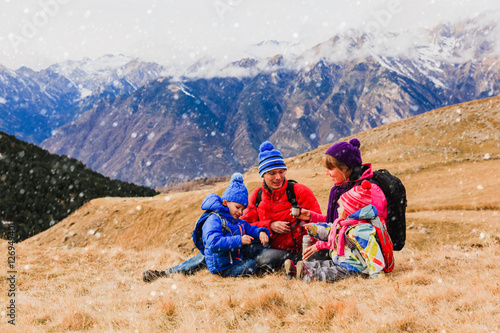 family with two kids travel in scenic winter mountains