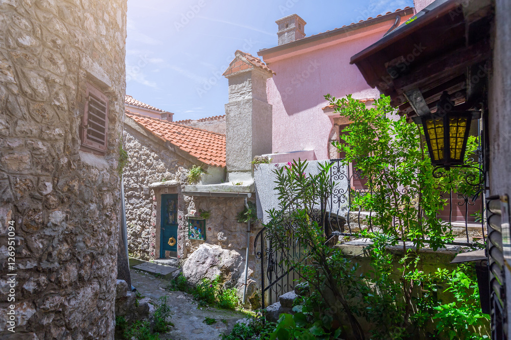 Traditional European Mediterranean architectural style in the streets and residential houses at summertime. Flowerpots stand on the stone steps.