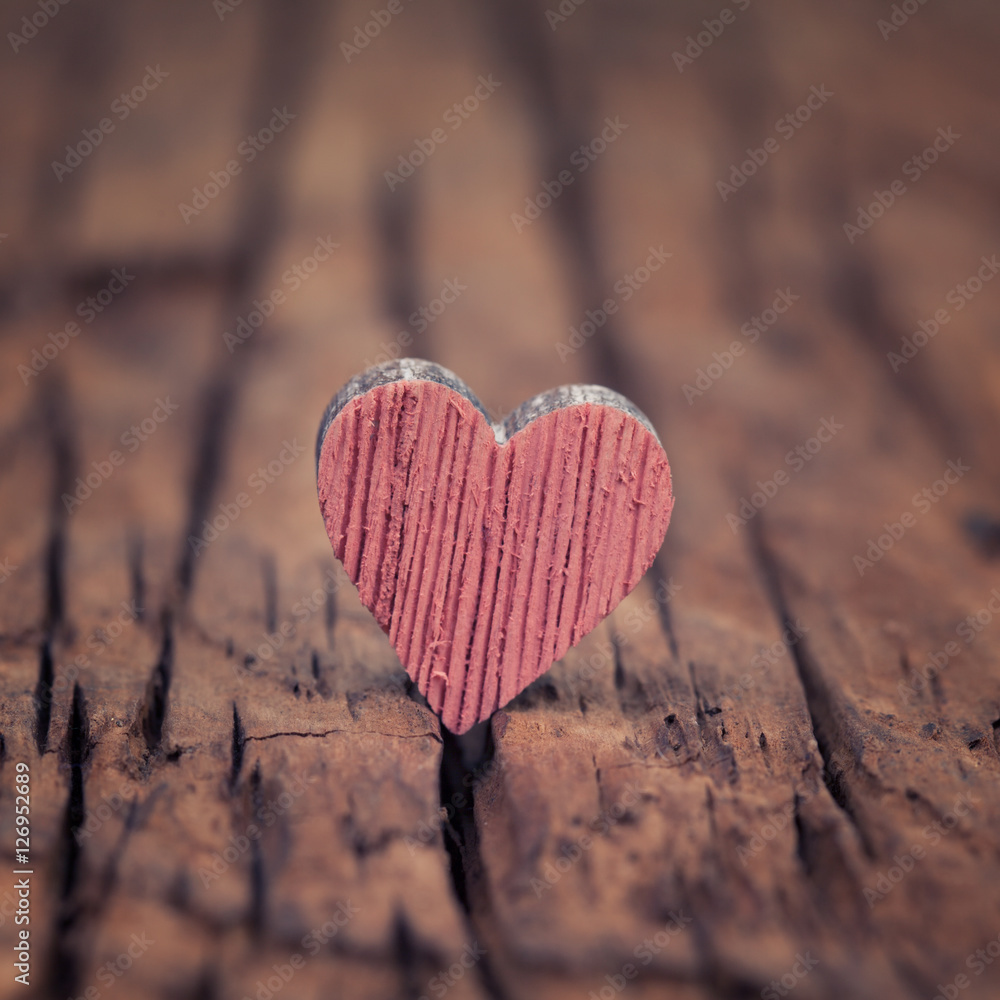 Fototapeta premium Pink wooden valentines heart on an old rustic wood