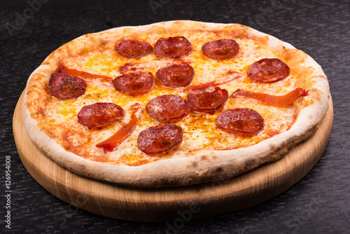 hot pepperoni pizza on wooden board