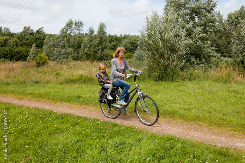 Senior woman with grandchild cycling with bike in nature © breedfoto