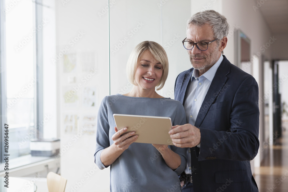 Businessman and woman having a meeting, looking at digital tablet Businessman and woman having a meeting, looking at digital tablet