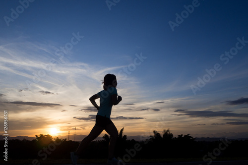 Fototapeta Naklejka Na Ścianę i Meble -  silhouette running woman on twilight sky in the evening.