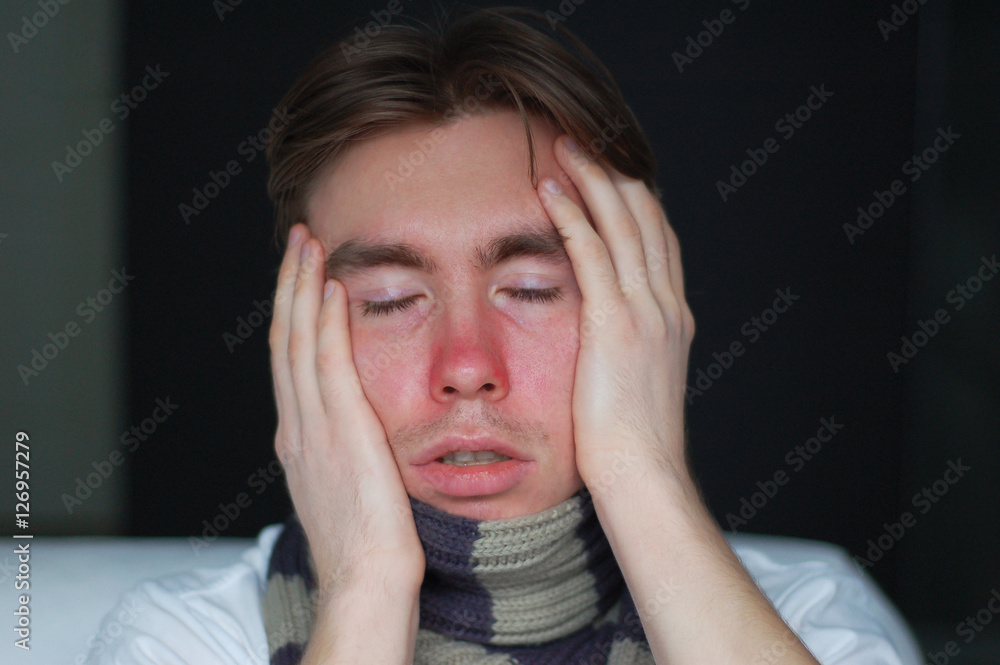 a young man suffering from a cold: chills, headache and stuffy nose a young man suffering from a cold: chills, headache and stuffy nose