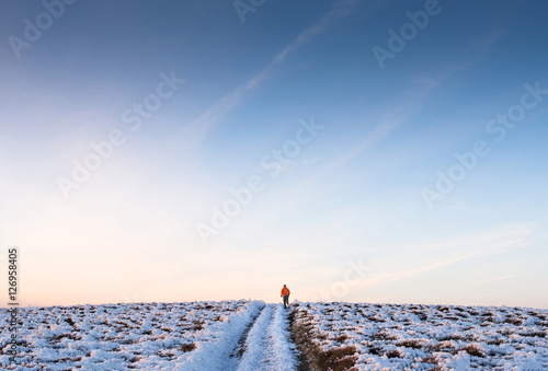 Sports boy runs to his goal on a snowy mountain road