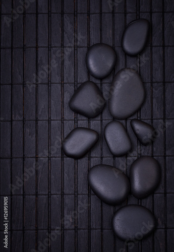 Canvas Print Black zen stones on a wooden black painted  dark surface