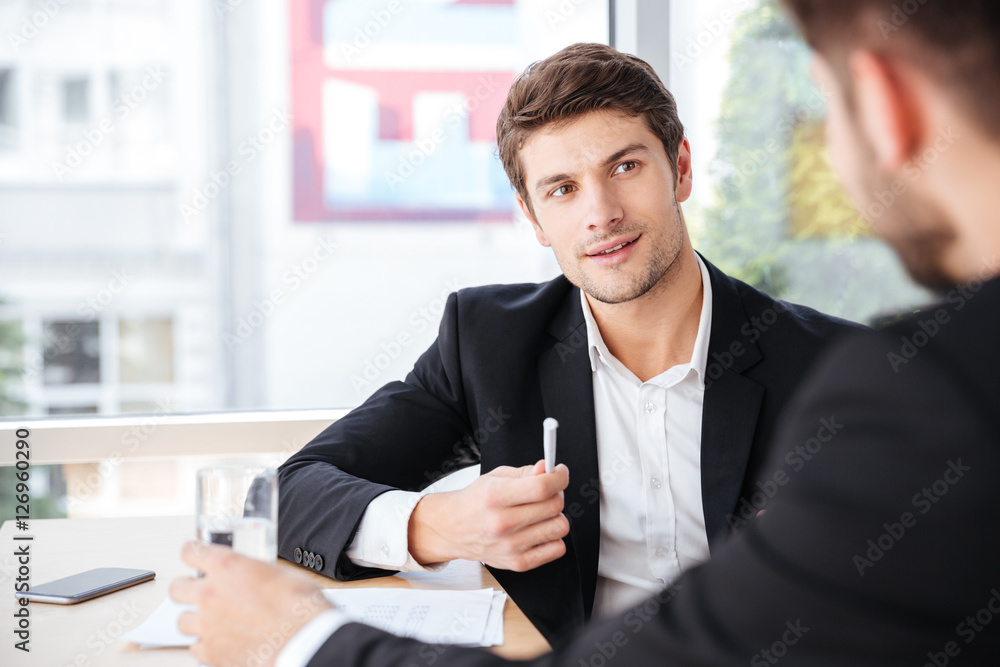 Businessman talking with his colleague in office Businessman talking with his colleague in office