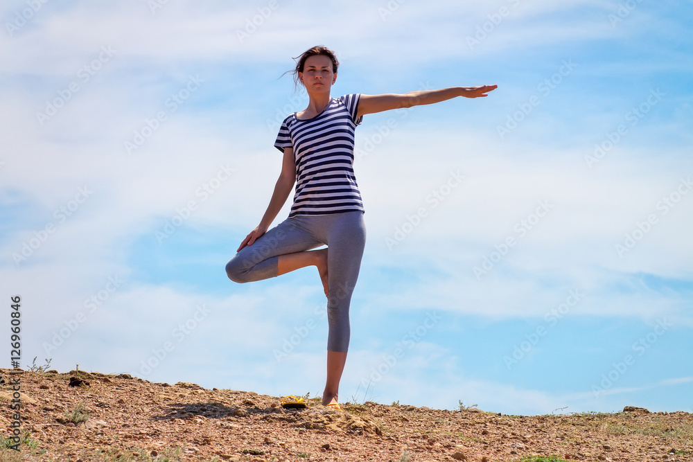 Young sportive girl doing yoga on the mountain Young sportive girl doing yoga on the mountain