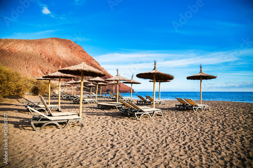 chaise-longues and sun umbrellas in Playa de la Tejita photo