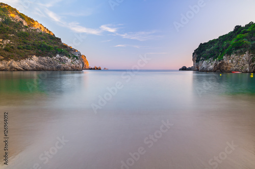 Long exposure landscape of Paleokastritsa famous sand beach in close bay on Corfu island at dusk, Ionian archipelago, Greece.