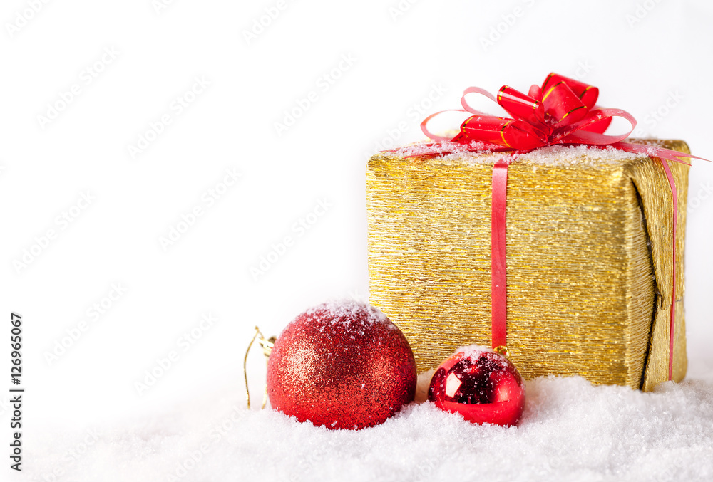 White greeting card with copy space for christmas or new year with golden wrapped gift and red ball on snow.