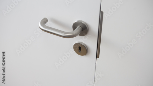 closeup of white door with silver door handle © wernerimages