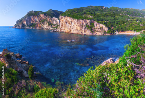 Fototapeta Naklejka Na Ścianę i Meble -  Landscape of Paleokastritsa famous beach in close bay with crystal clear azure water on Corfu island, Ionian archipelago, Greece.