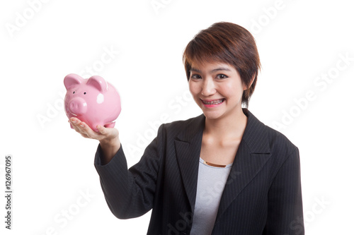 Young Asian business woman with a pig coin bank.