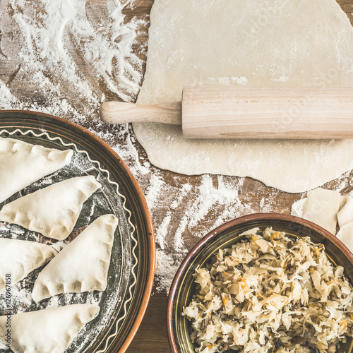 Making dumplings with sauerkraut and mushrooms, traditional Christmas Eve delicacy in Poland and Eastern Europe. High angle view, square. 