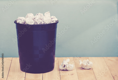 Recycle,trash bin and crumpled paper balls on wood 