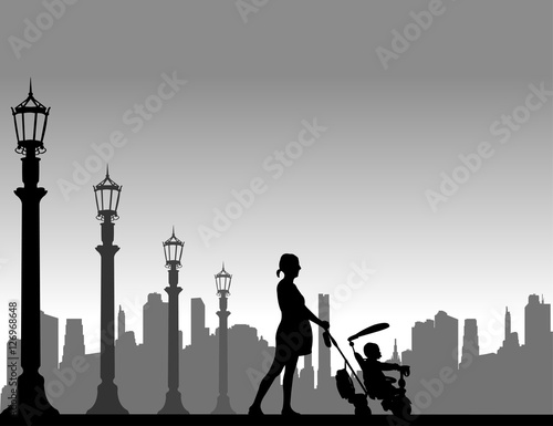 Pregnant woman walking with baby on a tricycle on the street, one in the series of similar images silhouette