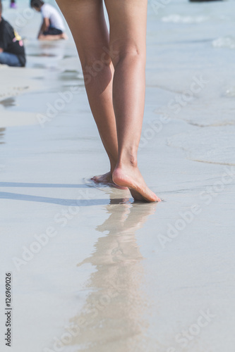 young woman standing at relax pose or freedom pose or chill pose on the beach in holiday.