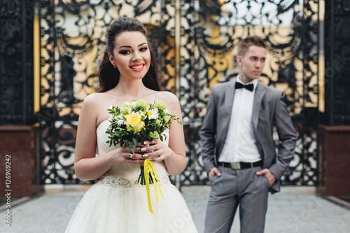 Bride with bouquet and groom on the background