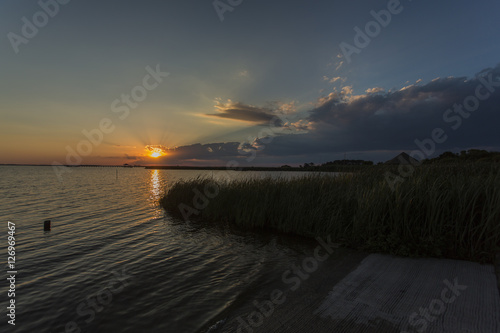 Sunset & clouds on water's edge with grasses, Outer Banks, NC