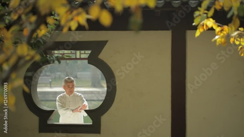 MS SELECTIVE FOCUS View through gazebo's window of mature man doing Tai Chi / Beijing, China
