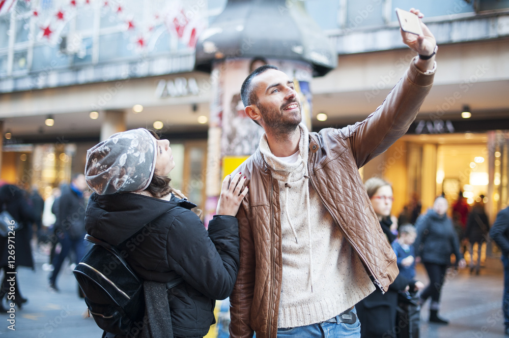 Young couple in love taking selfie with smart phone on the street Young couple in love taking selfie with smart phone on the street