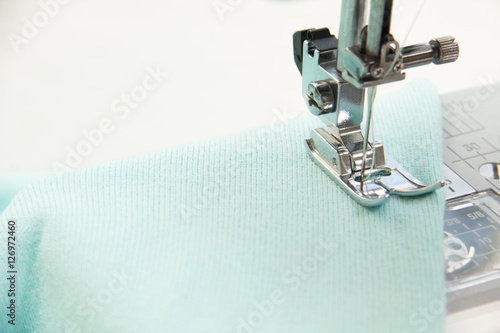 The sewing on the sewing machine turquoise fabric