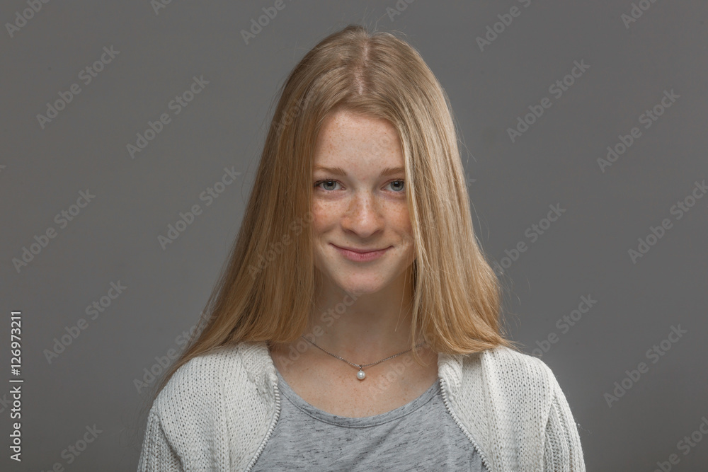 red-haired girl close up on a gray background red-haired girl close up on a gray background