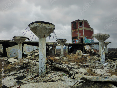 Abandoned automotive factory rooftop with crumbled concrete and debris
