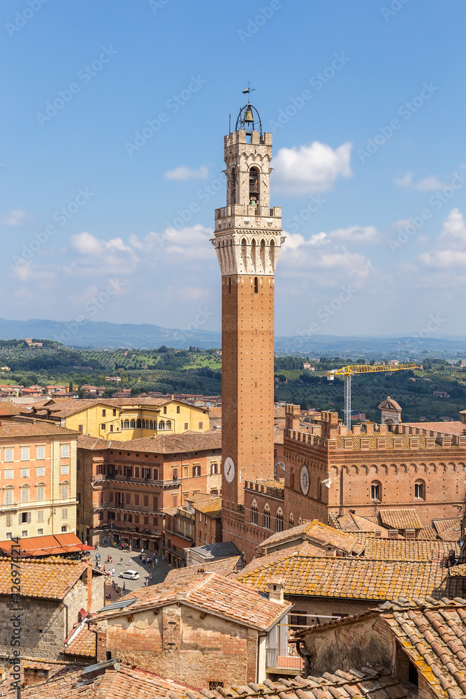 Siena, Italy. Torre del Mangia (Tower Beefeaters) and the medieval Commune Palace (Palazzo Publico), the former royal residence of the 12-16 centuries, in Piazza del Campo