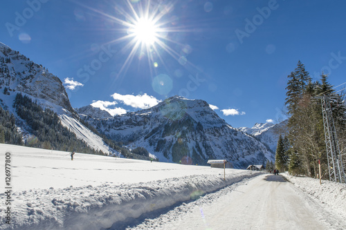 Blick auf verschneite Berglandschaft im Allgäu gegen die strahlende Sonne