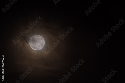 smeared silhouettes of flying birds with a rare full moon in the background