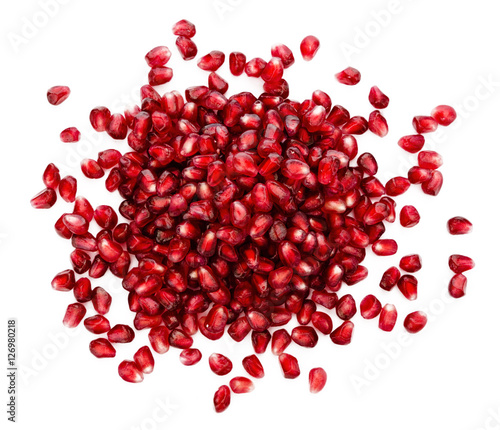 fresh exotic ruby pomegranate seeds, scattered on isolated white background