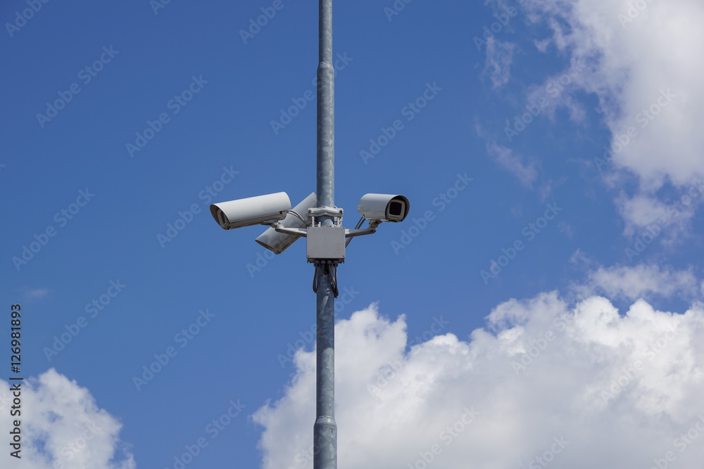 security cctv cameras on a pole with blue sky background