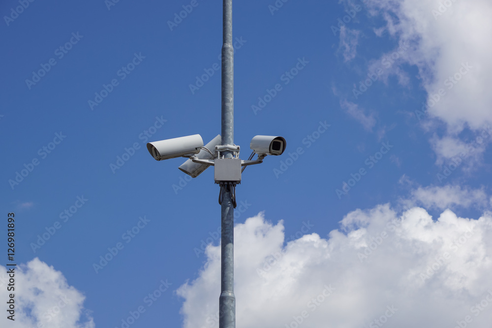 security cctv cameras on a pole with blue sky background security cctv cameras on a pole with blue sky background