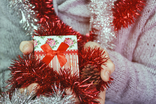 Hombre joven sujetando un regalo de navidad con decoración navideña  photo