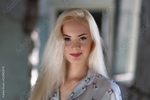 Beautiful young blonde girl with a pretty face and beautiful eyes smiling. Portrait of a woman with long hair and amazing looks. Looking hot girl with a tender look.