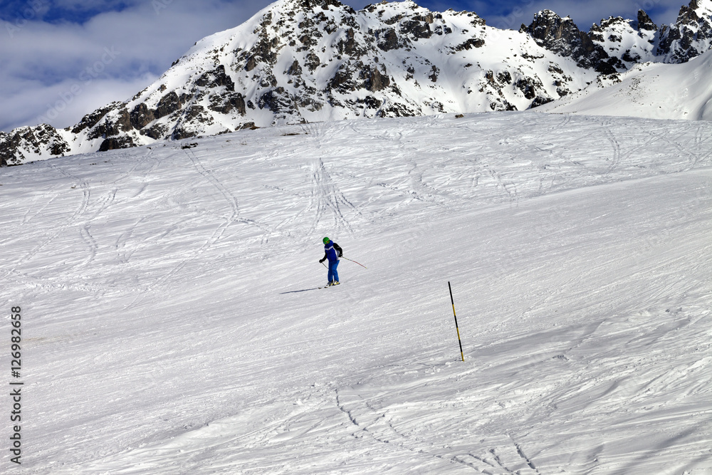 Skier on ski slope at sun winter day